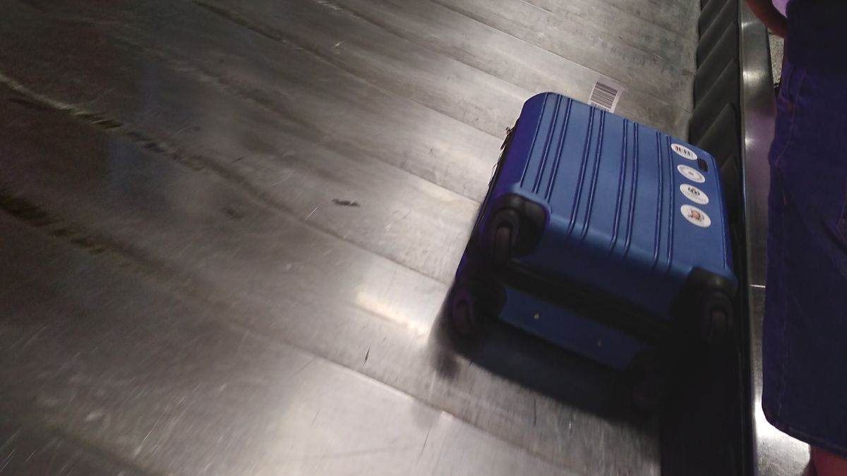 Maleta azul en la faja de recojo del aeropuerto, donde se reporta el equipaje perdido o dañado